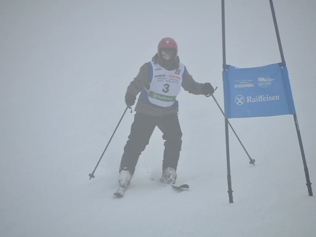 Skifahrer mit Startnummer 3 im Nebel auf der Rennstrecke.